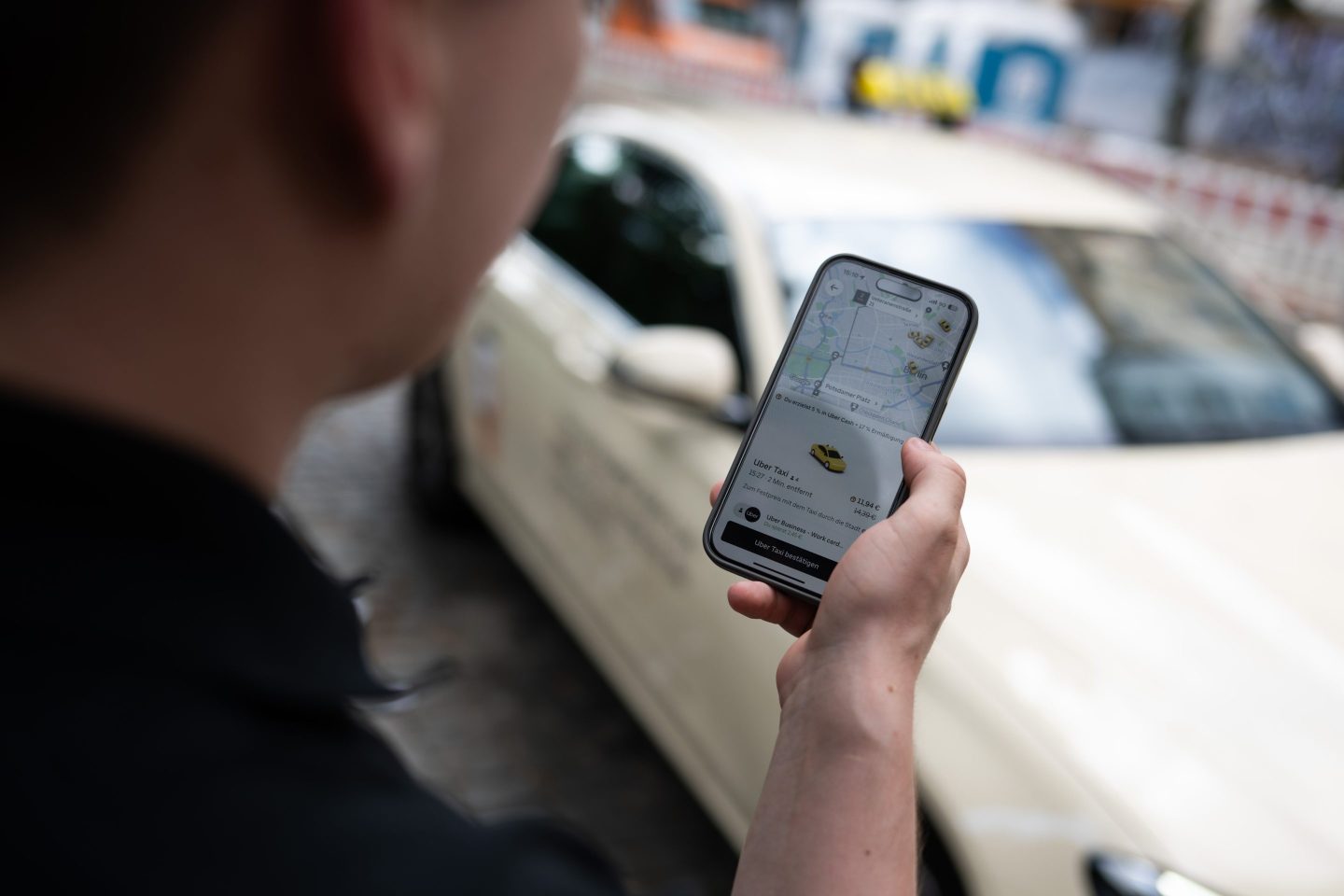 Someone uses the Uber app to hail a ride.