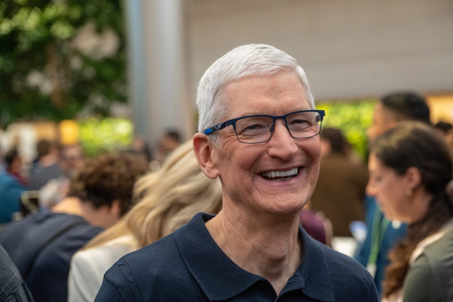 Tim Cook, CEO of Apple, is seen smiling.