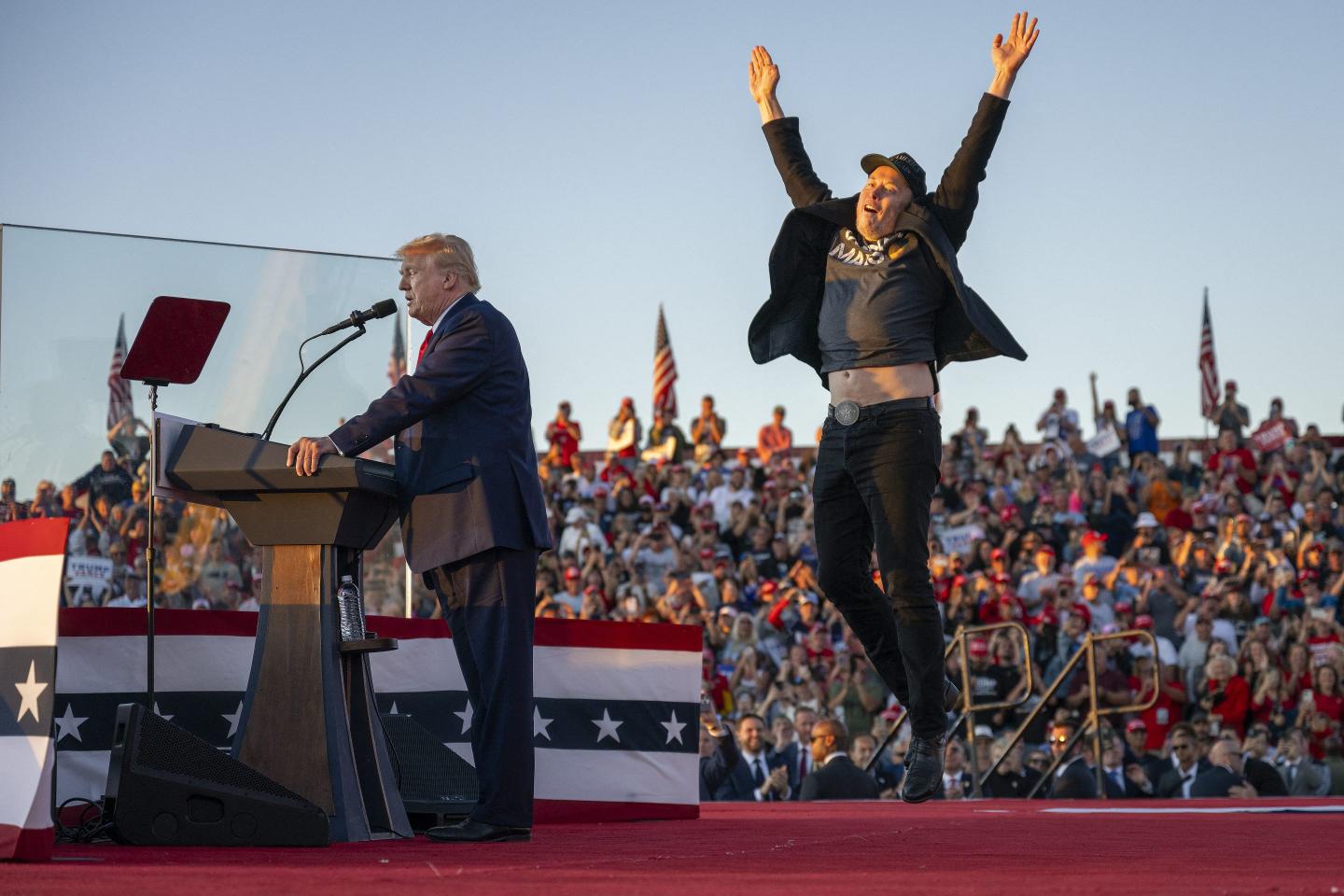Elon Musk jumping in the air on stage at an October 2024 rally for Donald Trump.