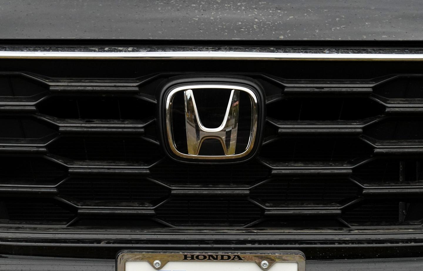 The Honda logo on the front bumper of a Honda car
