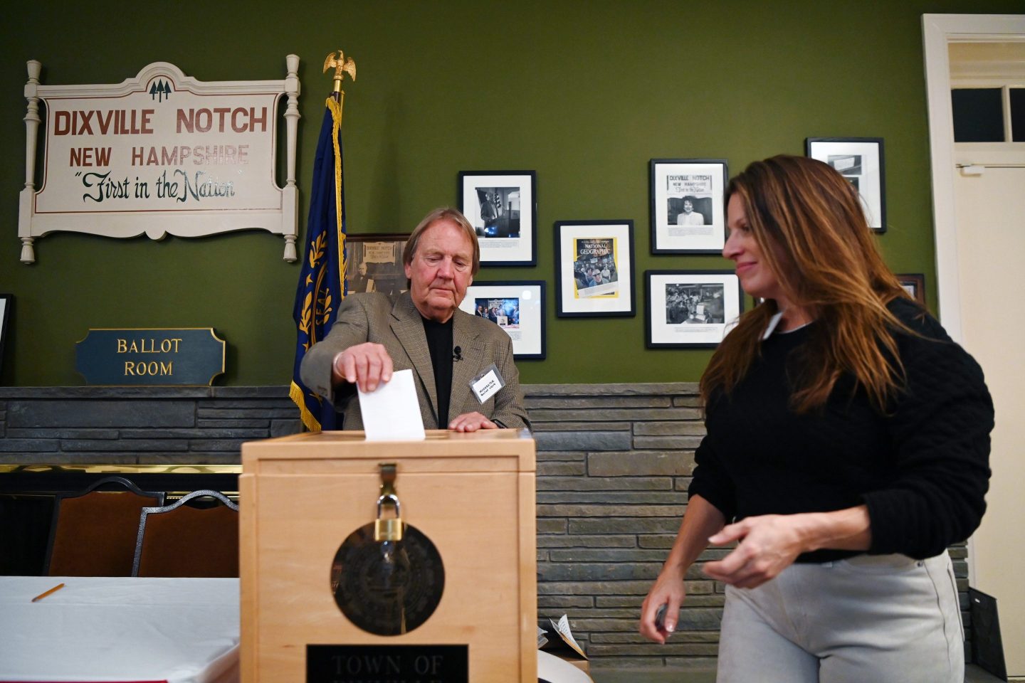 A moderator helps a voter cast her ballot in Dixville Notch, N.H.