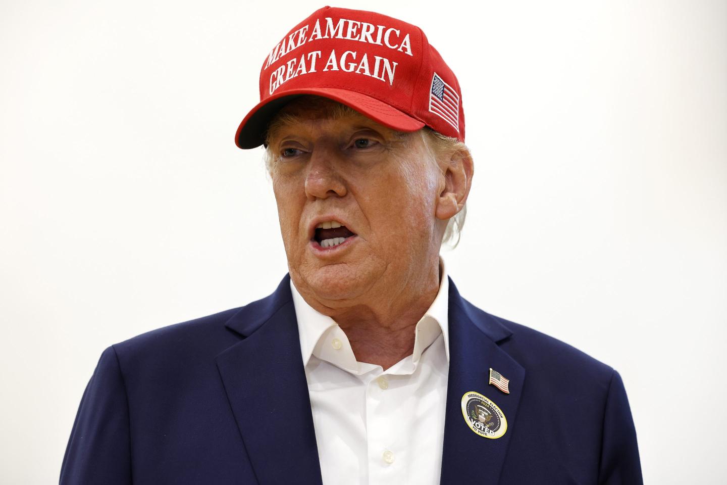 Trump appears with his mouth open and a MAGA hat