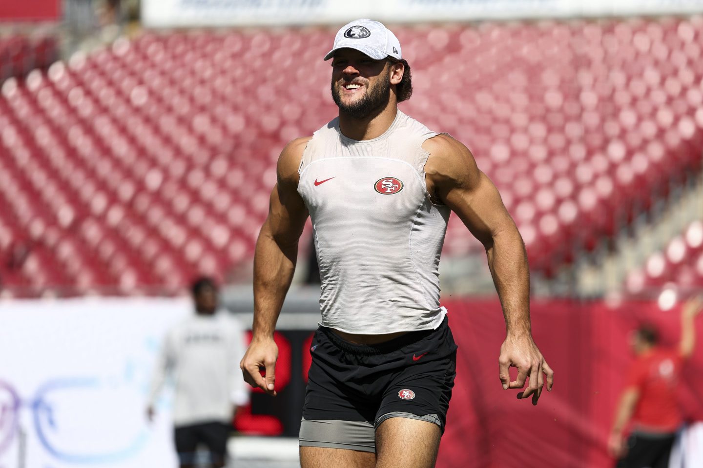 Nick Bosa flexes while working out on the field