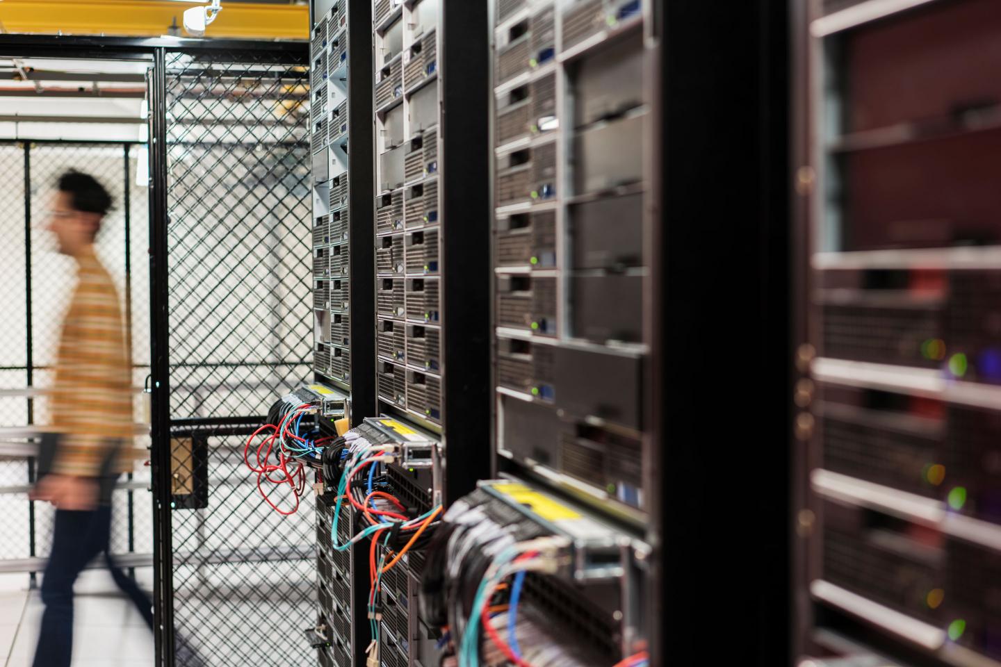 Technician walking in computer server room.