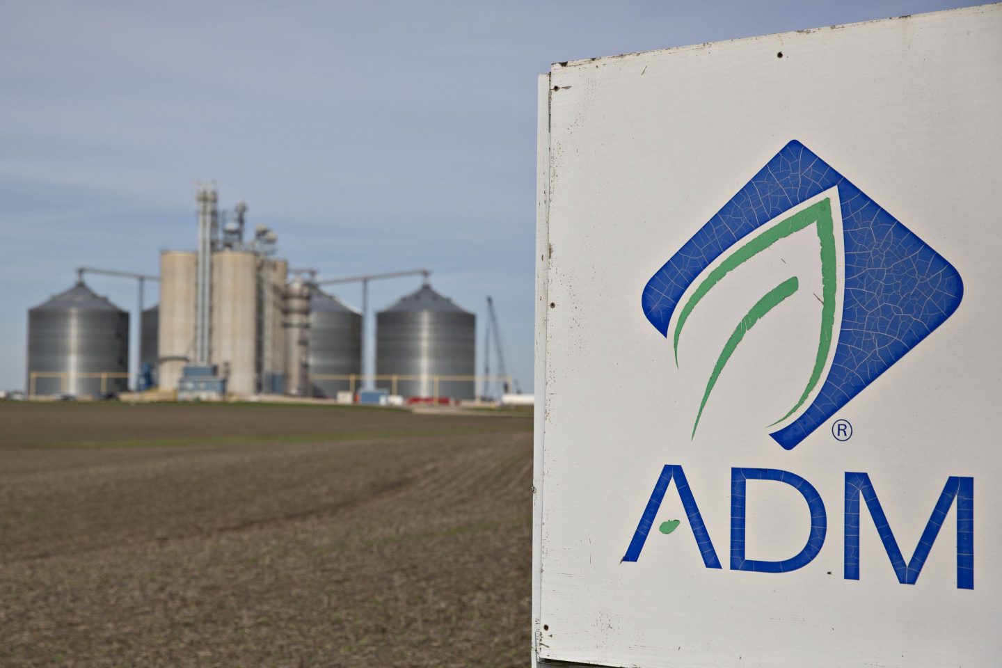 a sign with the letters "ADM" outside of a grain facility