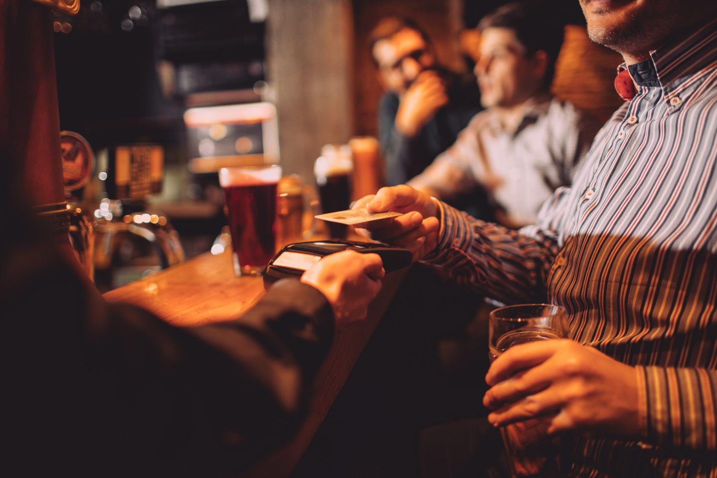 A person paying for drinks at a bar