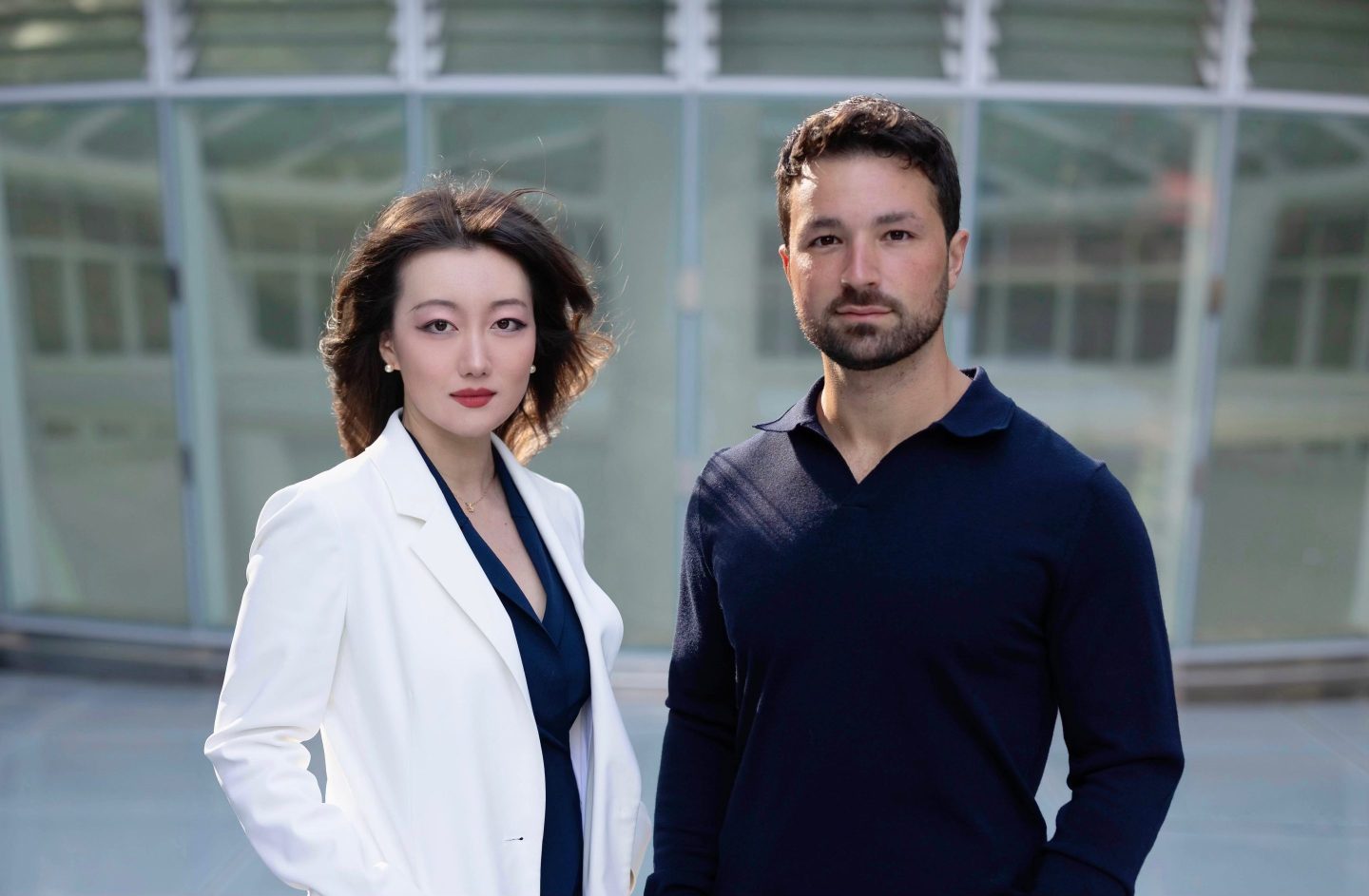 woman in lab coat and man in business professional clothes pose for a photo