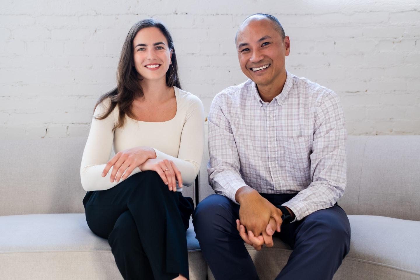 a woman and a man sit down for a photo portrait