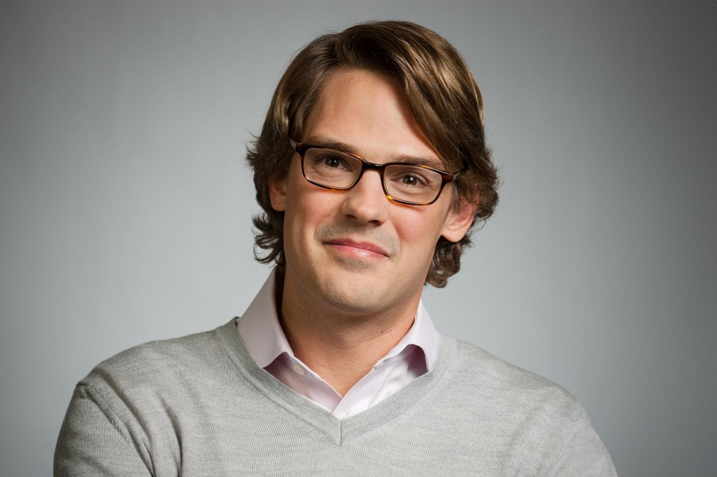 man in glasses, collared shirt, and sweater