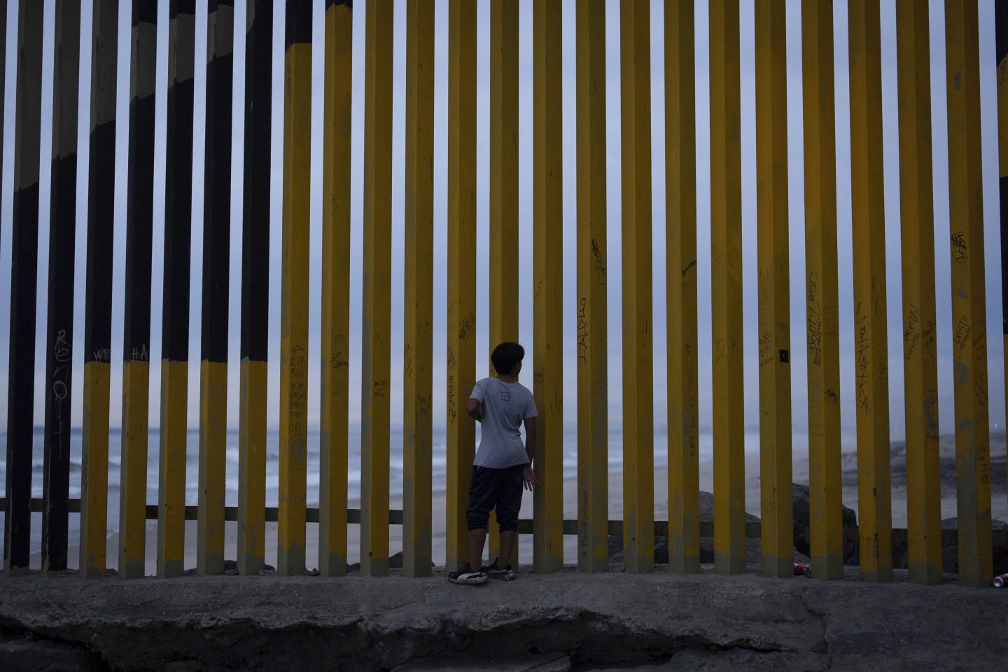 A boy looks through a border wall separating Mexico from the United States, Nov. 26, 2024, in Tijuana, Mexico.