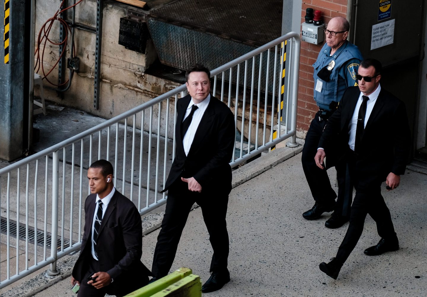 Tesla CEO Elon Musk surrounded by bodyguards.