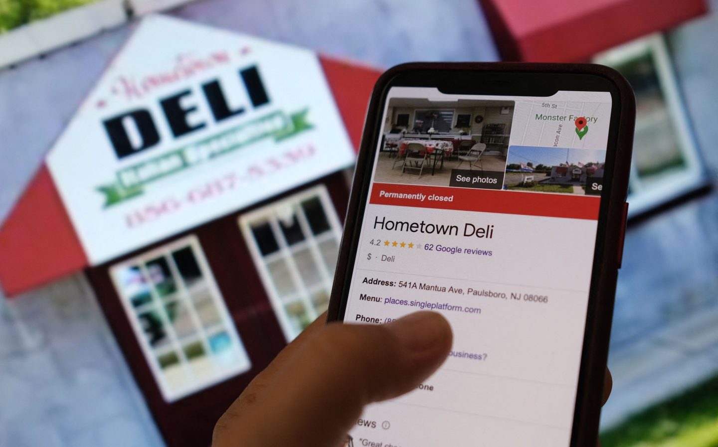 This illustration photo shows a person checking information online for the now permanently closed Paulsboro, New Jersey's Hometown Deli in front of a screen displaying the facade of the restaurant.