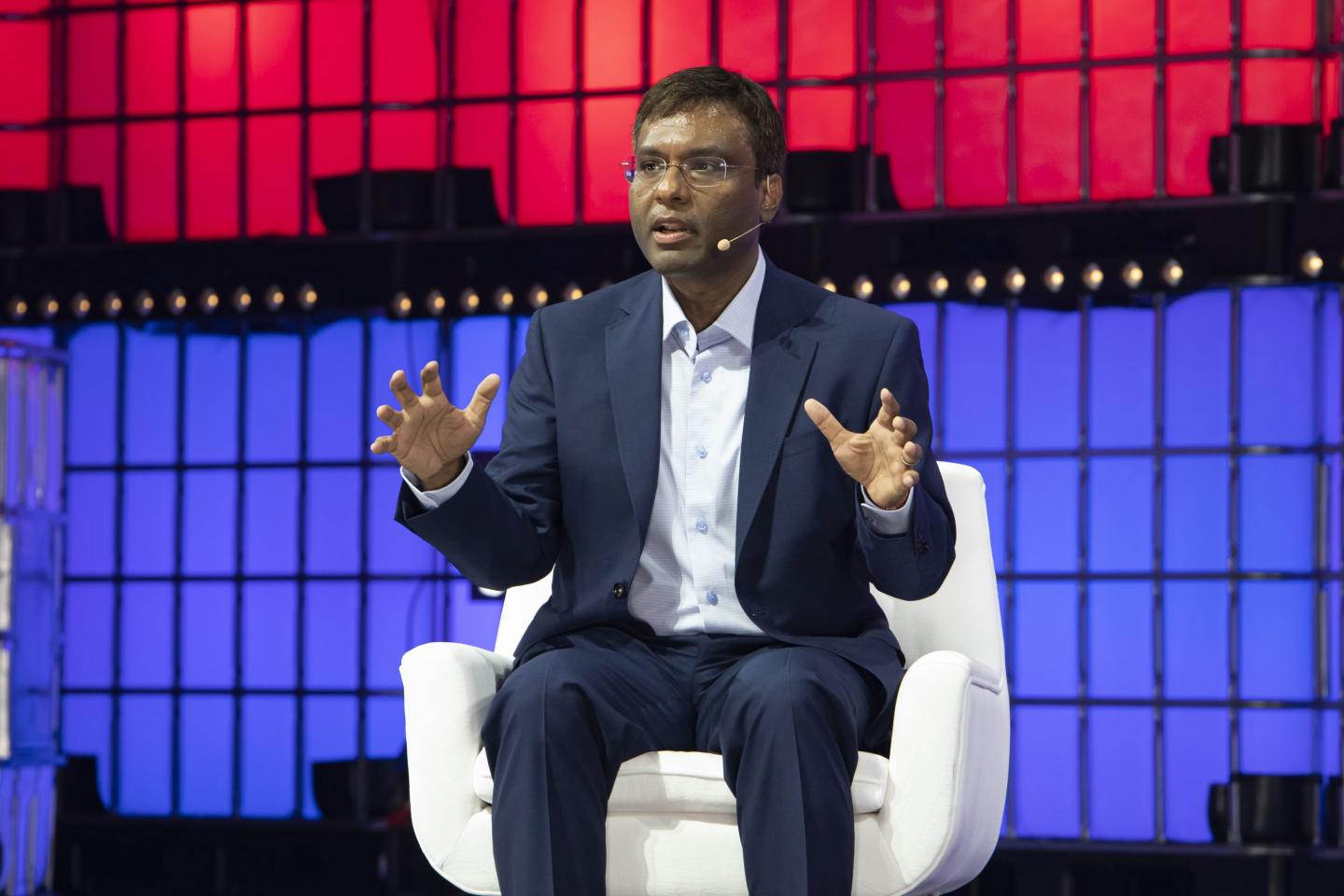 Amazon's Rohit Prasad sitting in a chair on stage at a tech conference.