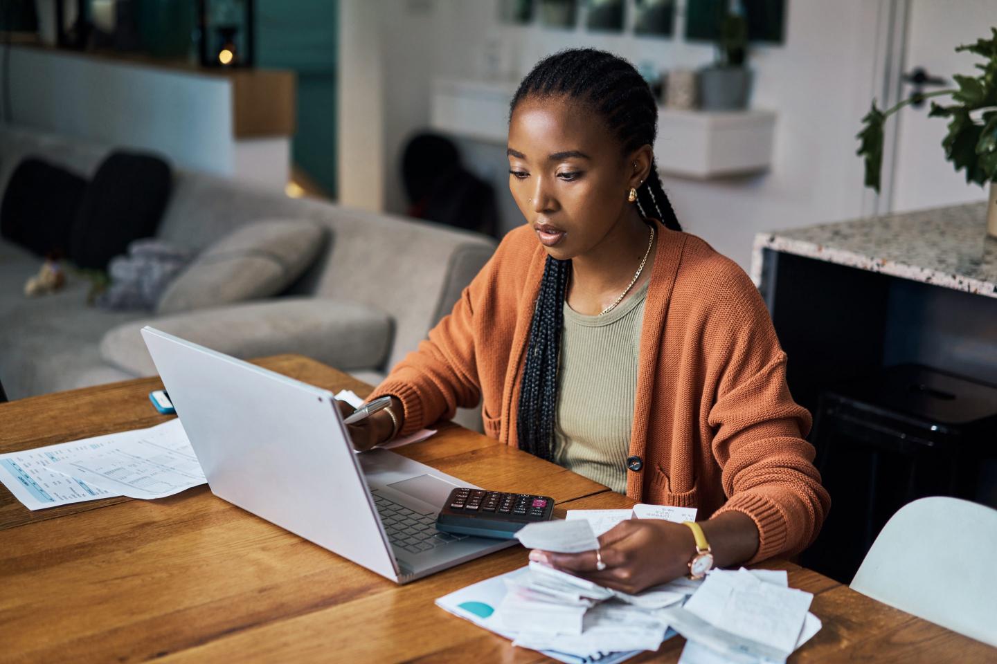 Woman working on budget and home finance on laptop for accounting.