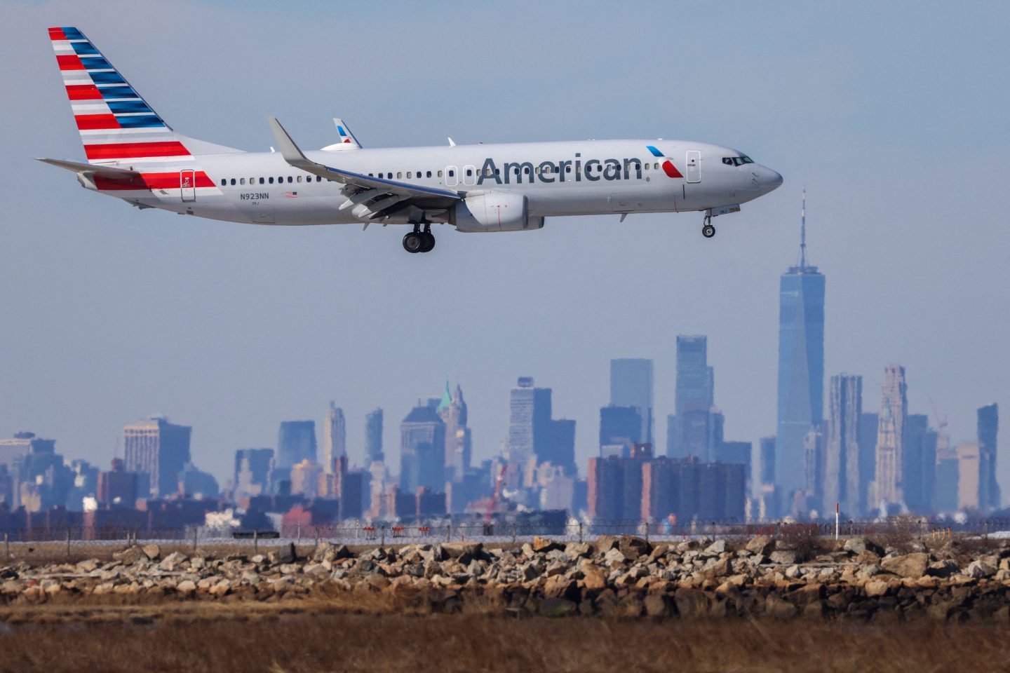 A Boeing 737 passenger aircraft of American Airlines arrives from Austin at JFK International Airport in New York as the Manhattan skyline looms in the background on February 7, 2024.