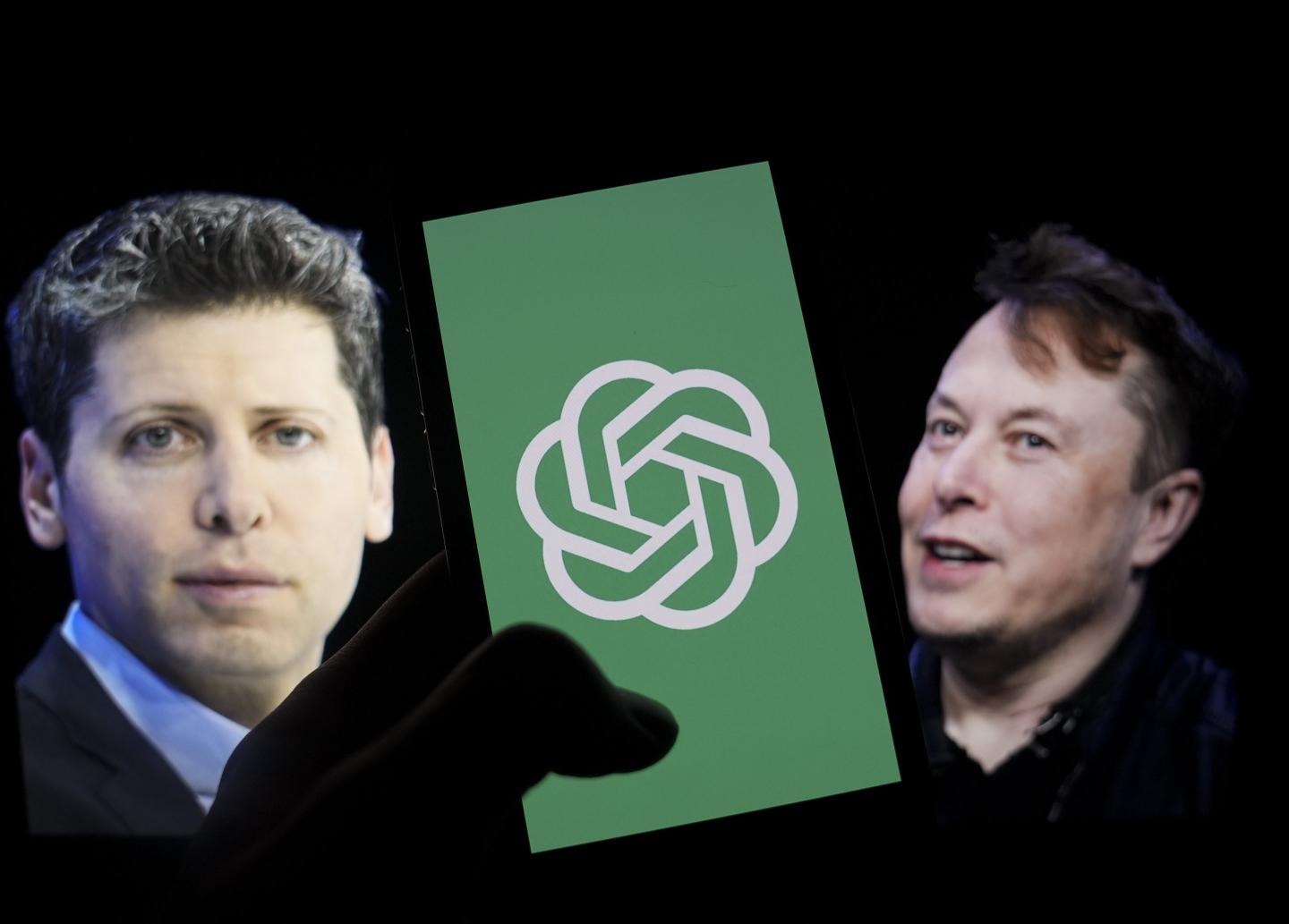 In this photo illustration, the logo of 'OpenAI' is displayed on a mobile phone screen in front of a computer screen displaying the photographs of Elon Musk and Sam Altman in Ankara, Turkiye .