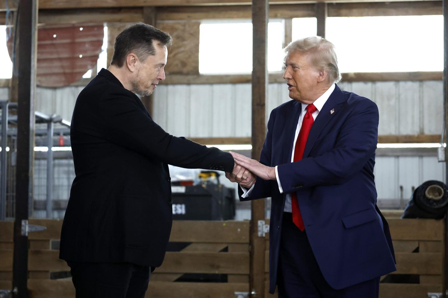 Elon Musk (L) shakes hands with Republican presidential nominee, former President Donald Trump