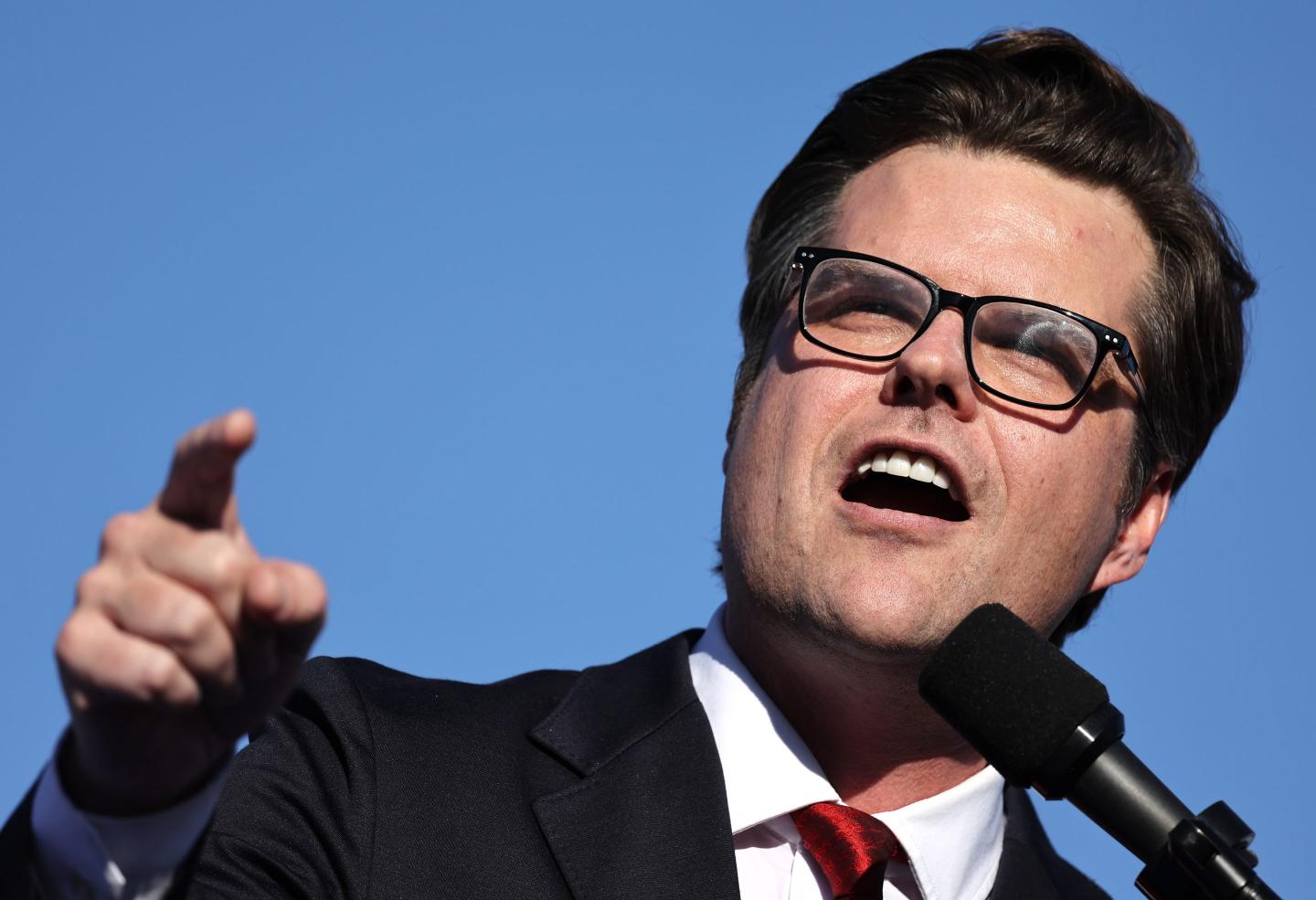 Matt Gaetz speaks in front of a microphone, holding his finger up