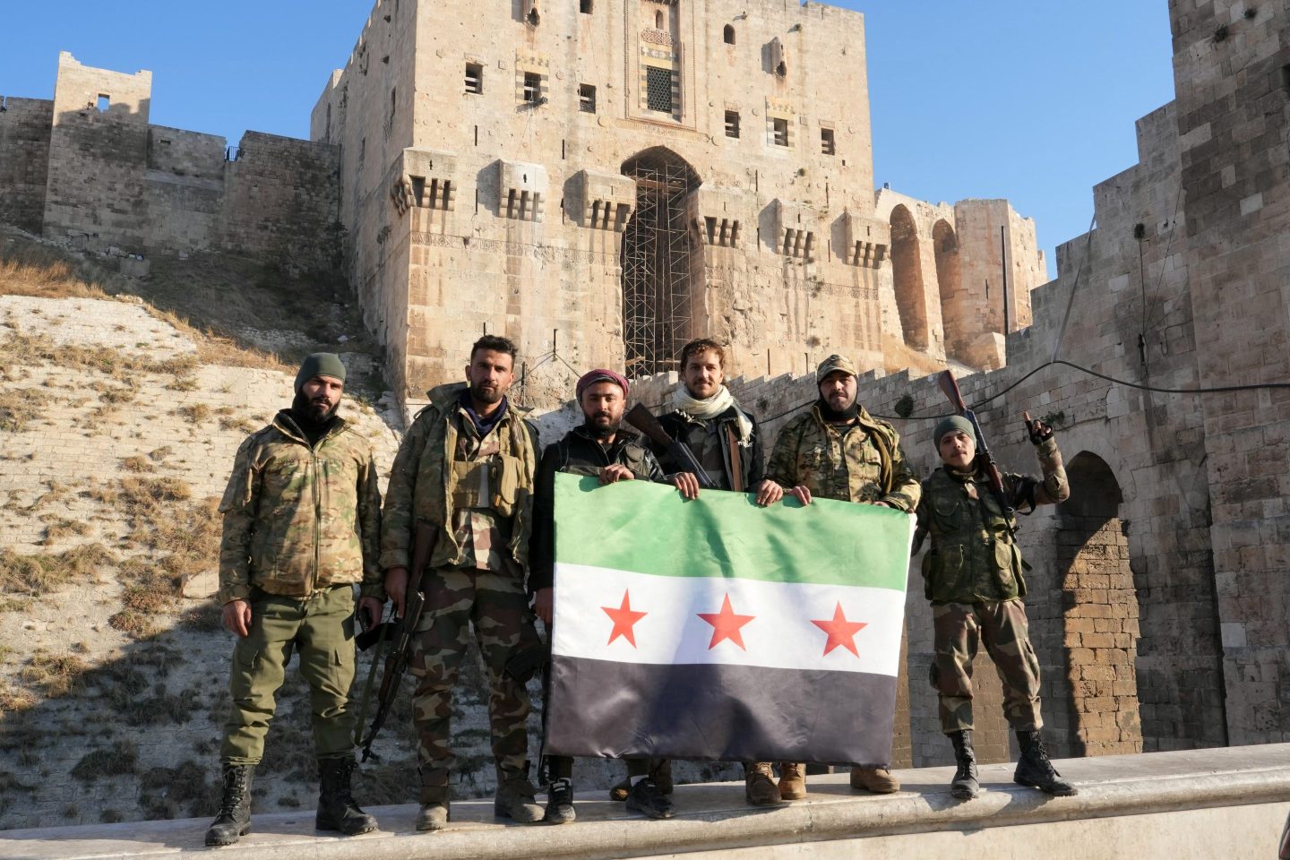 Anti-government fighters hold an opposition flag at citadel in Aleppo on Nov. 30.