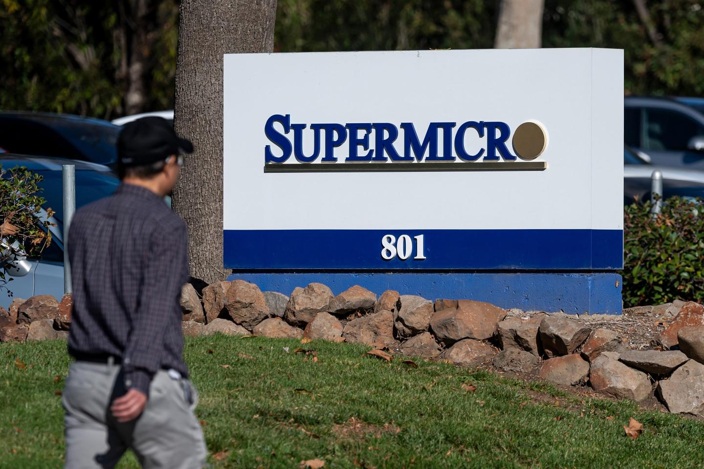 man walks past a sign at the Super Micro Computer Inc. headquarters