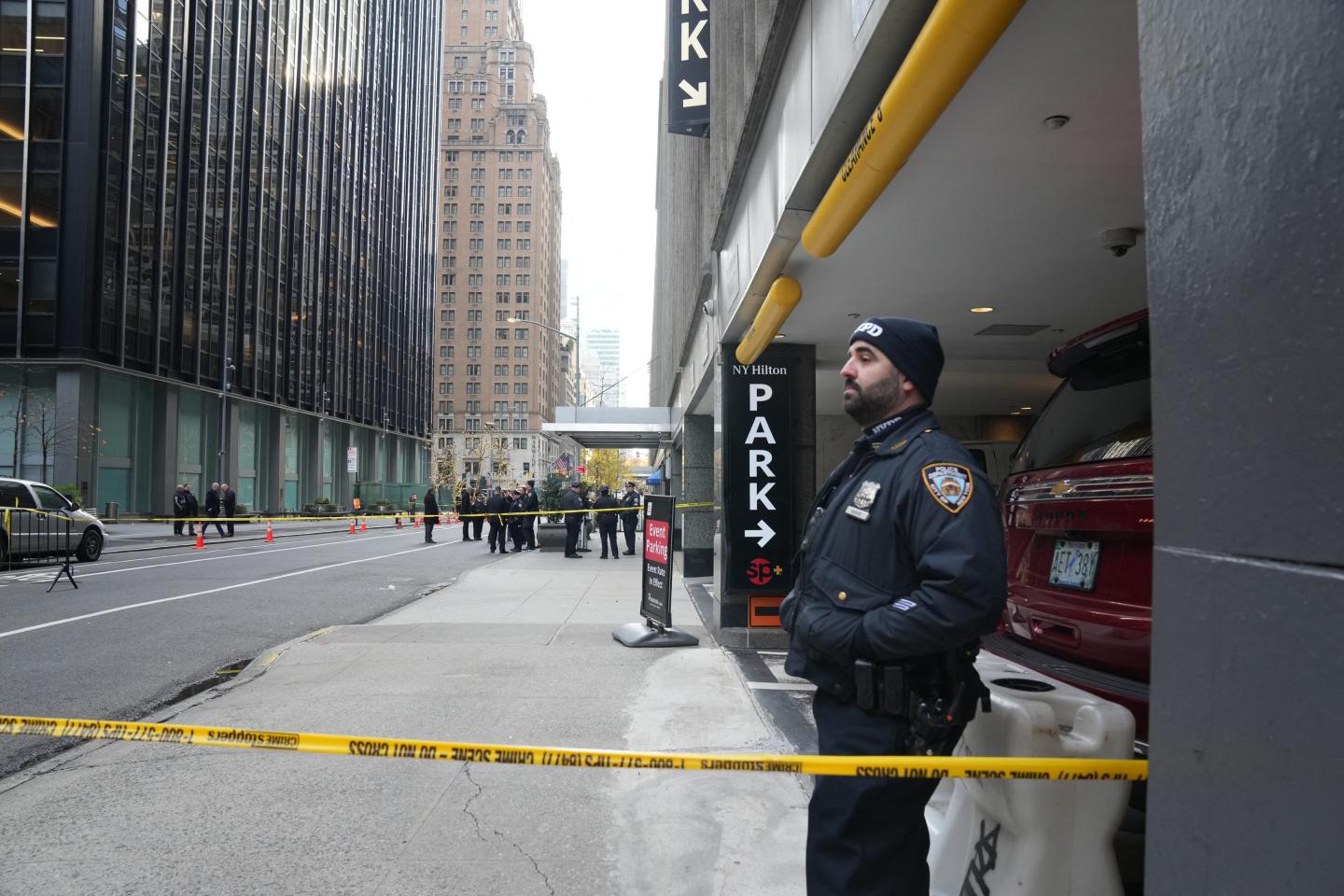 police officer and yellow caution tape shown on a new york city street outside a hotel building