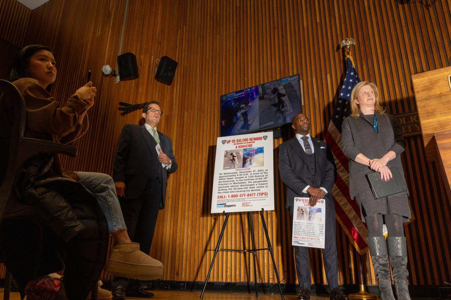 NYPD police commissioner Jessica Tisch stands next to a large wanted poster.