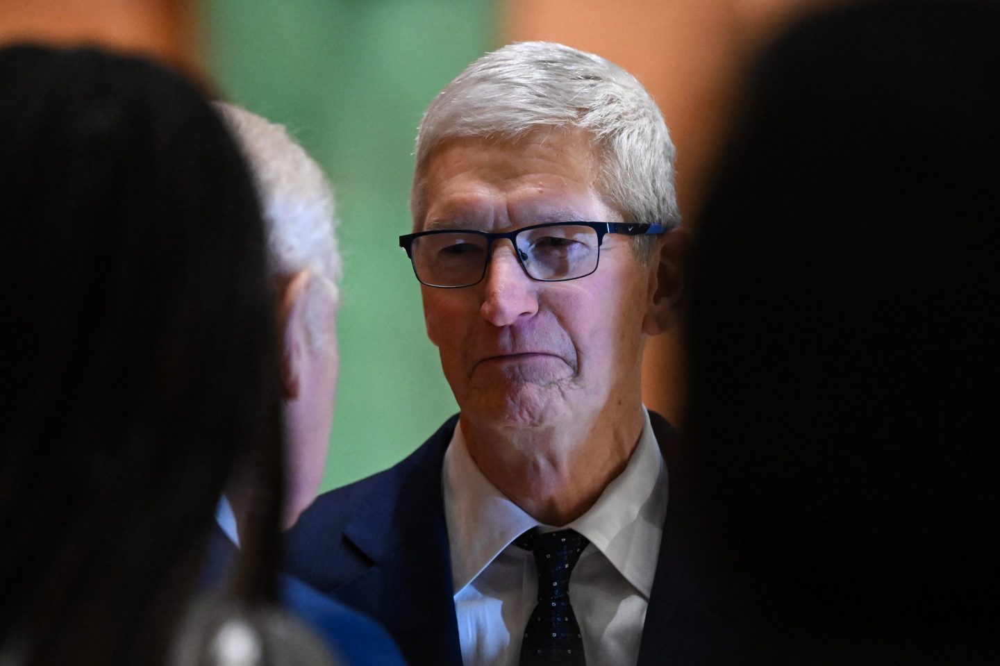 Tim Cook scowls while waiting to meet with King Charles III