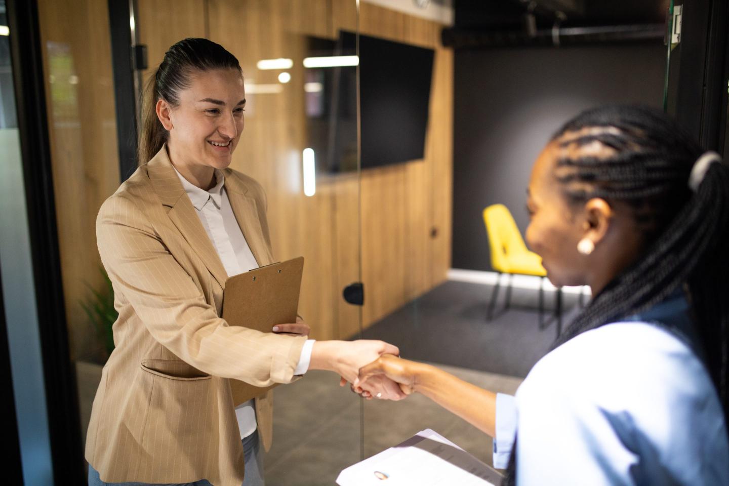 Hiring manager greets applicant for job interview.