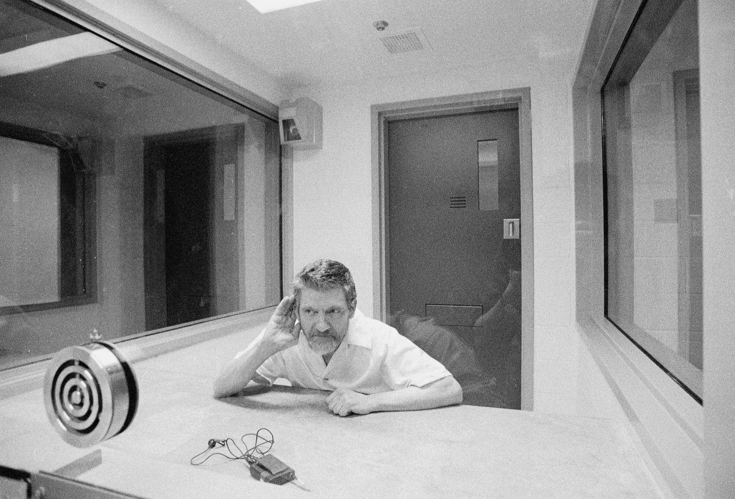 Ted Kaczynski cups a hand to his ear during an interview in a visiting room at ADX, a federal prison in Florence, Colo., Aug. 30, 1999.