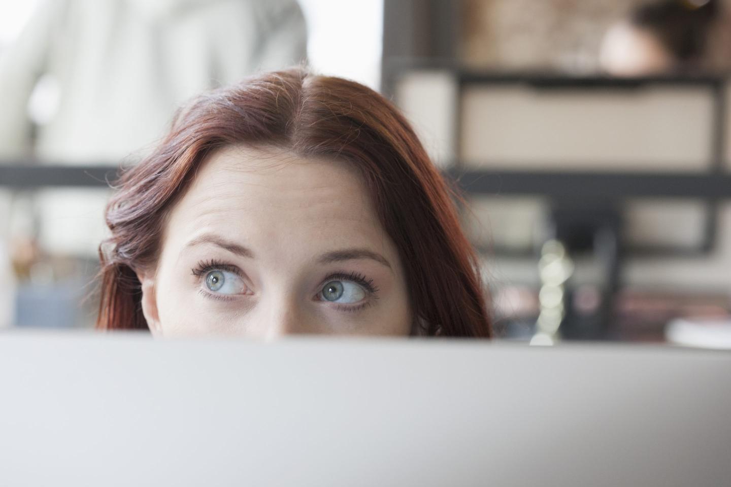 Caucasian businesswoman looking away from computer