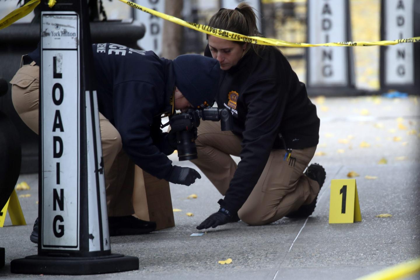 Police examine evidence at the site of Brian Thompson's shooting