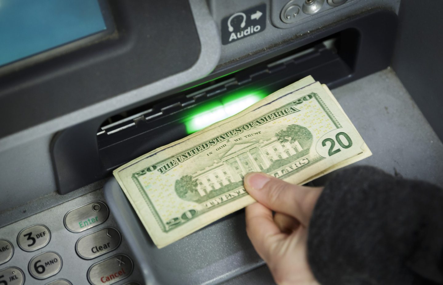 Hand removing money from ATM machine
