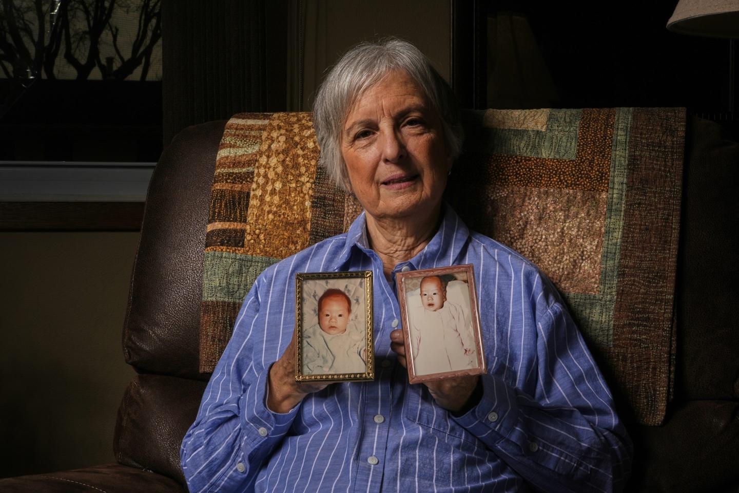 Peg Reif holds pictures of her children adopted from South Korea
