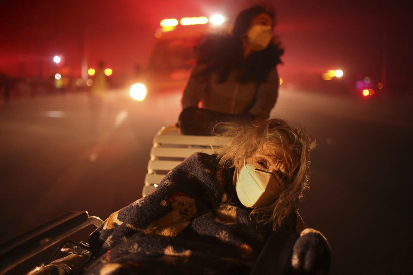 Out-of-control wildfires around Los Angeles force thousands to flee as flames torch homes and threaten senior center