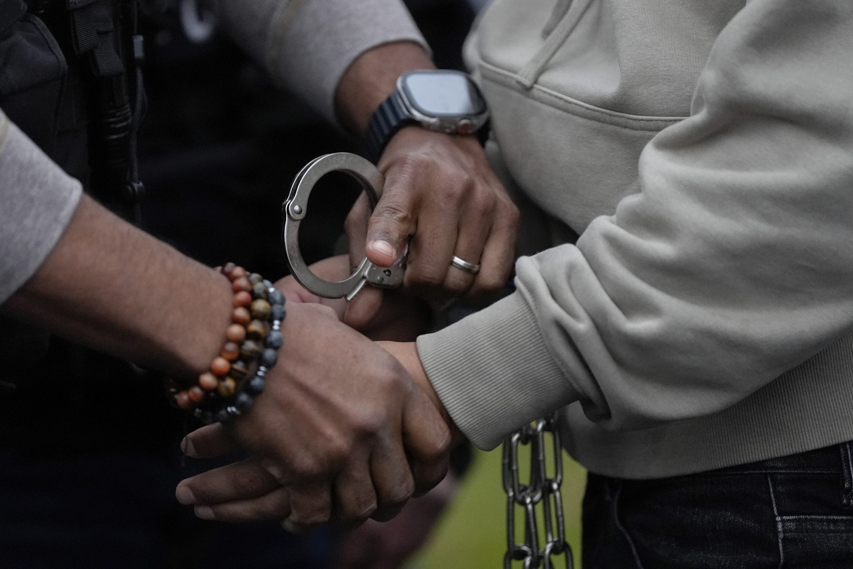 A U.S. deportation officer changes the handcuffs of Wilmer Patricio Medina-Medina from back to front after arresting him during an early morning operation, Dec. 17, 2024, in the Bronx borough of New York. 