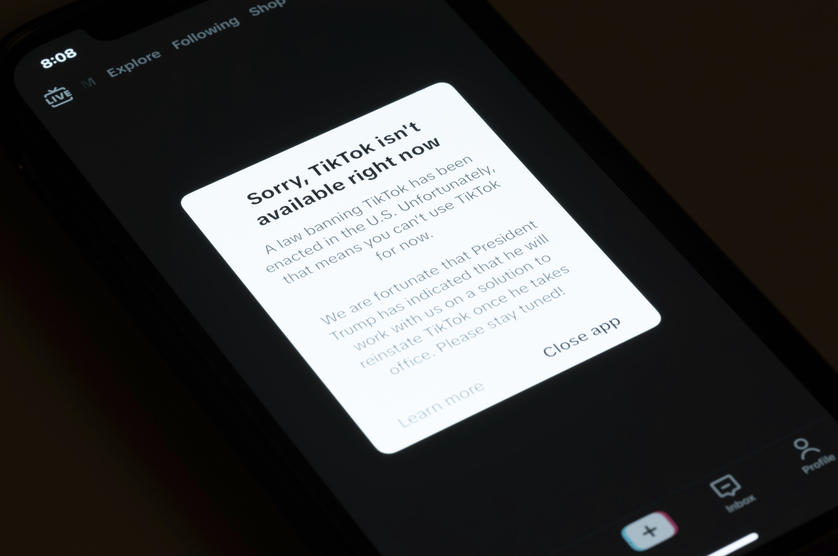 A message reading "Sorry, TikTok isn't available right now" is displayed from the TikTok app on a cell phone screen.