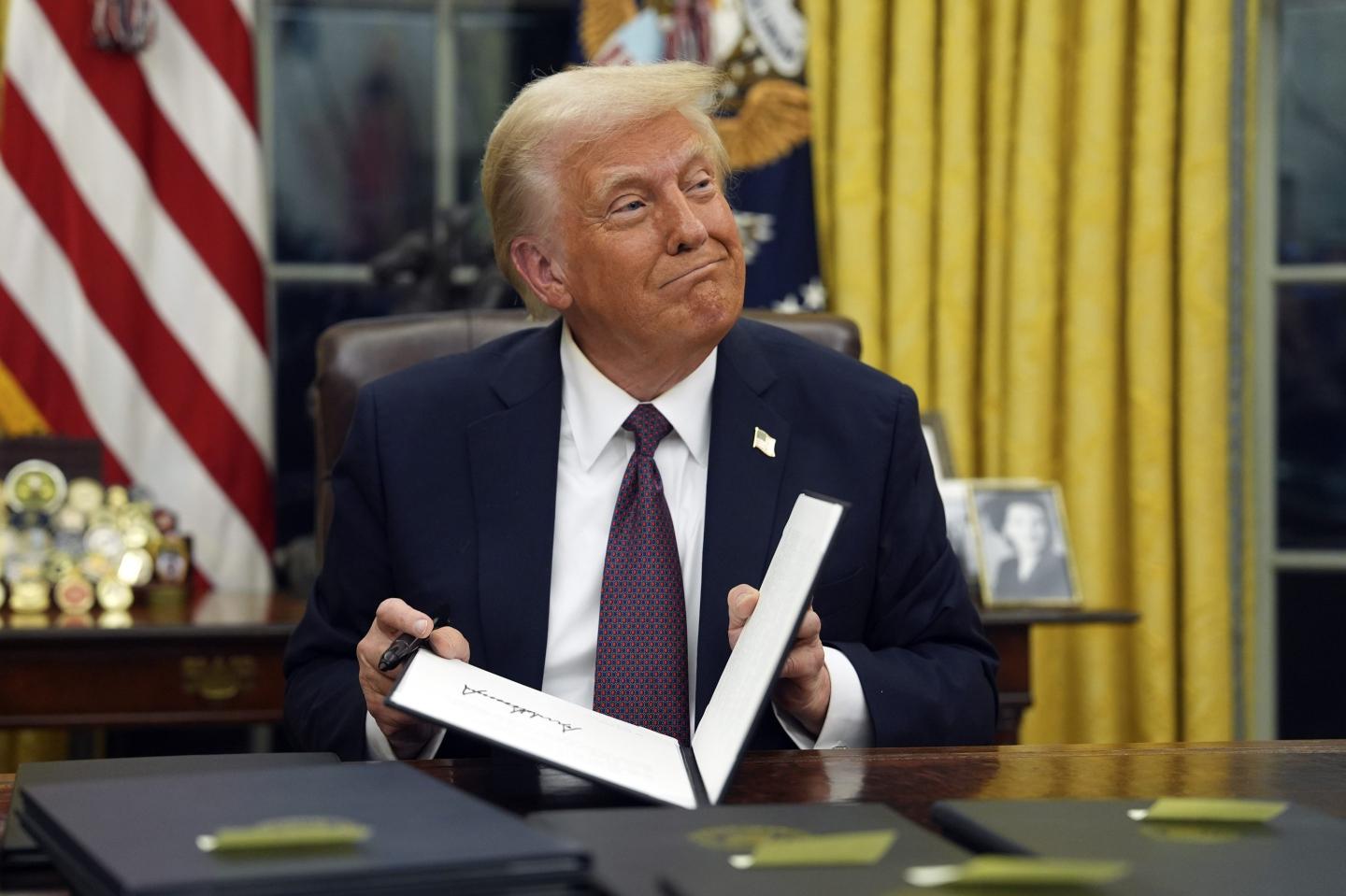 President Donald Trump signs executive orders in the Oval Office of the White House, on Jan. 20, 2025, in Washington.