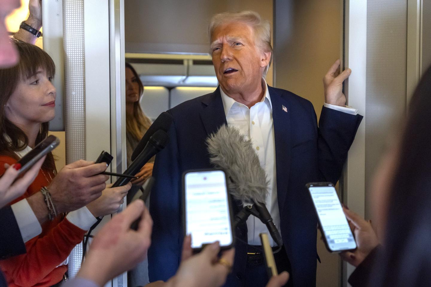 President Donald Trump speaks to reporters aboard Air Force One as he travels from Las Vegas to Miami on Saturday.