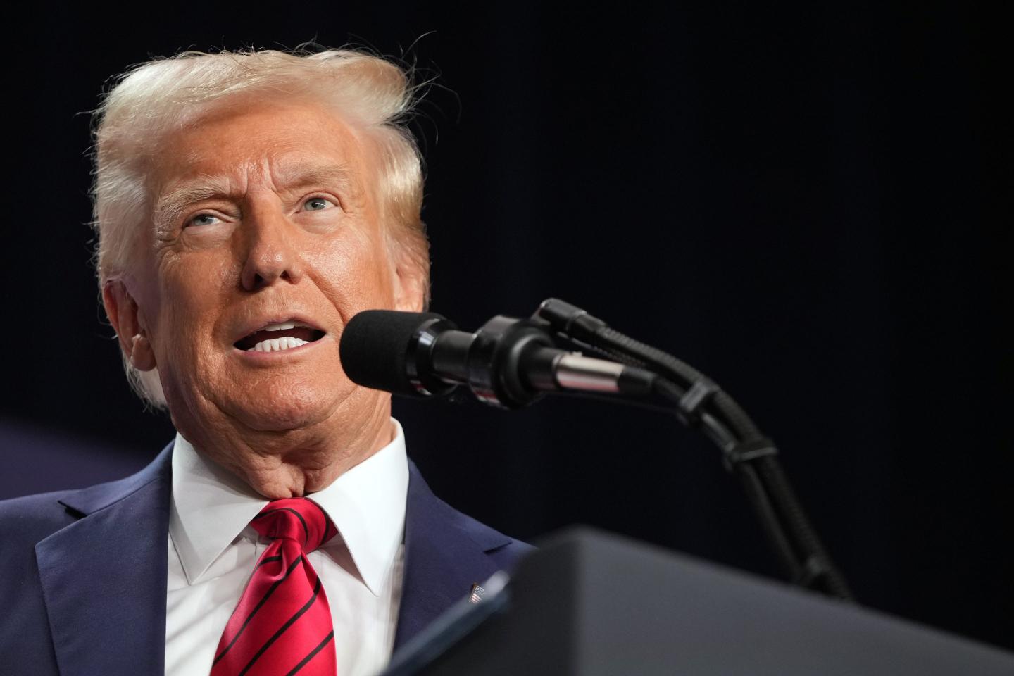 Trump speaks in front of a microphone