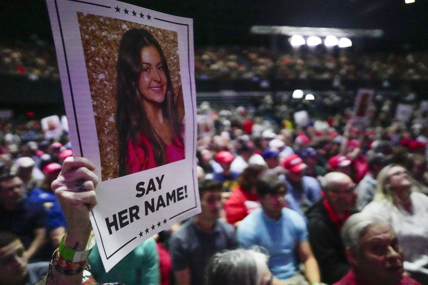 A supporter holds a poster with a photo of Laken Riley before Republican presidential candidate former President Donald Trump speaks at a campaign rally March 9, 2024, in Rome Ga.