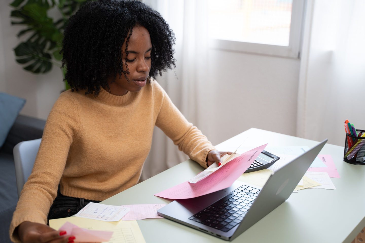 Accountant managing invoices and bills at home office desk.