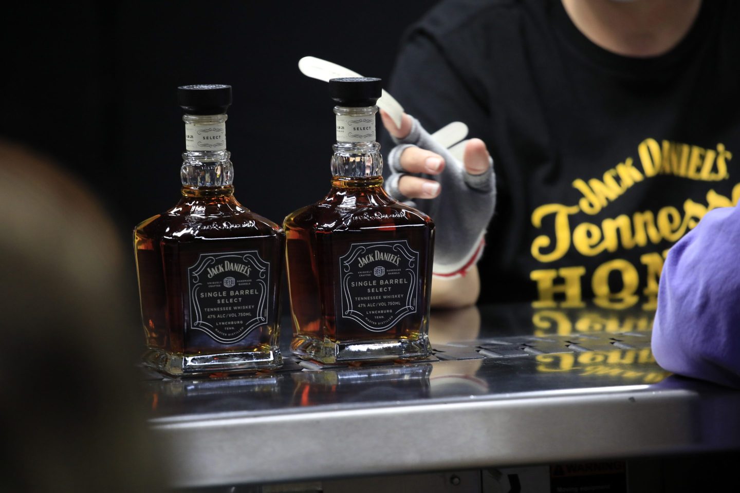 Workers attach labels to bottles of BrownForman Corp. brand Jack Daniel's Single Barrel Select Tennessee Whiskey at the company's distillery