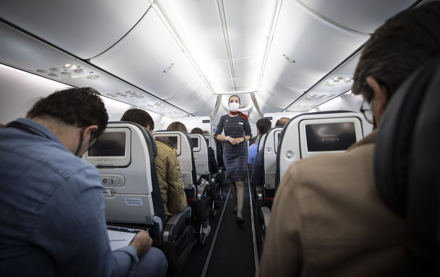 A Turkish Airlines flight attendant giving passengers a security a security briefing.