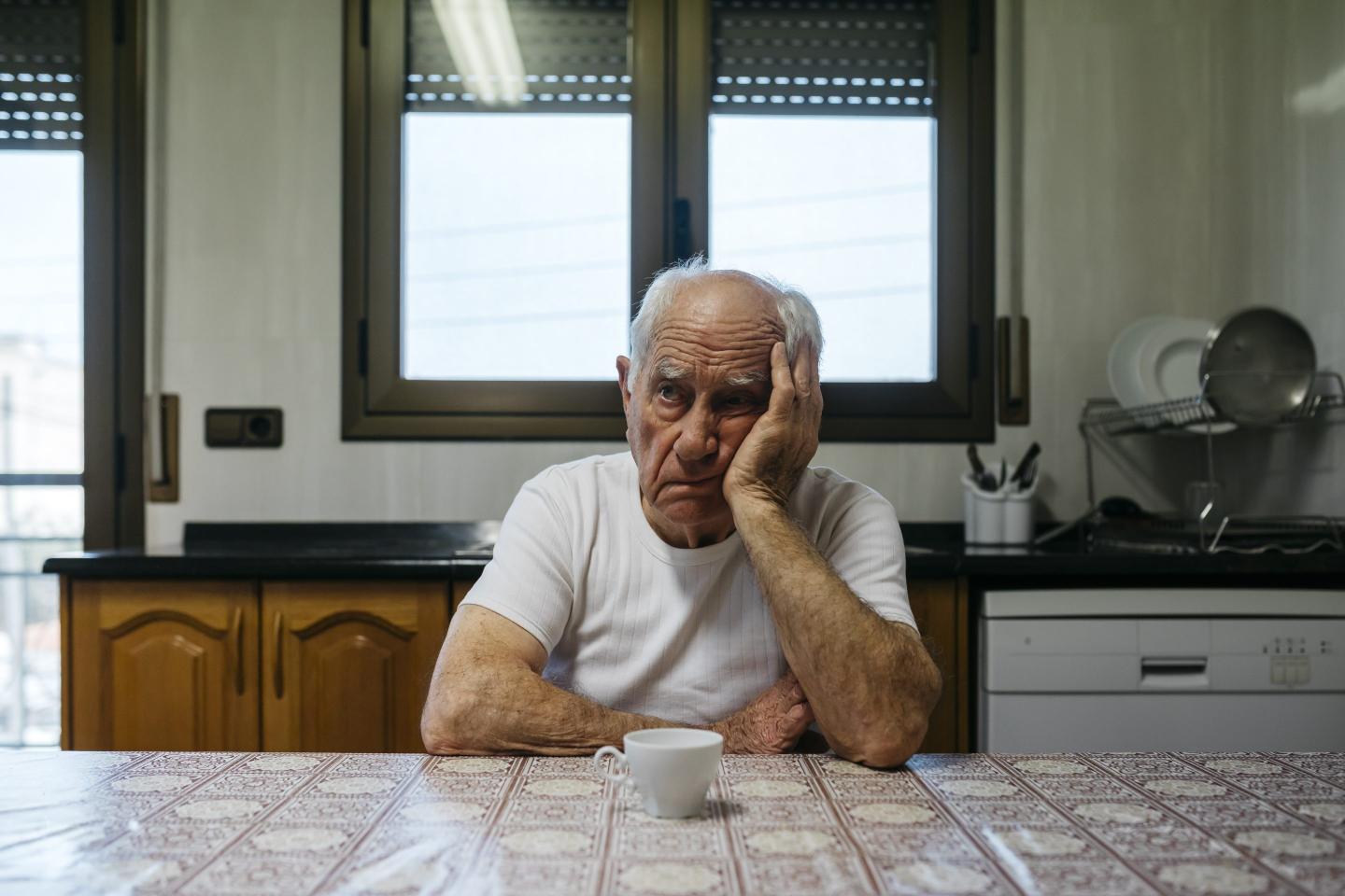 A man sitting at a table looking bored