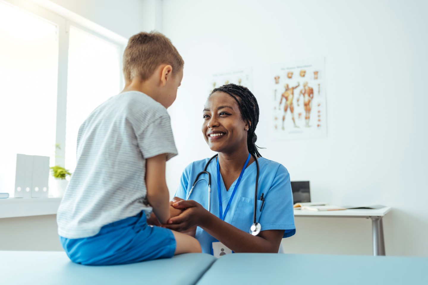 Female doctor consoling her young patient and holding his hand