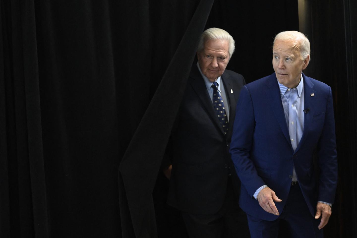 Steelworkers union president David McCall and Joe Biden peek out from behind a black curtain