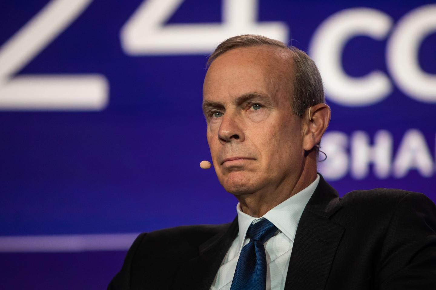 Chevron's CEO sitting in a chair, looking not too thrilled