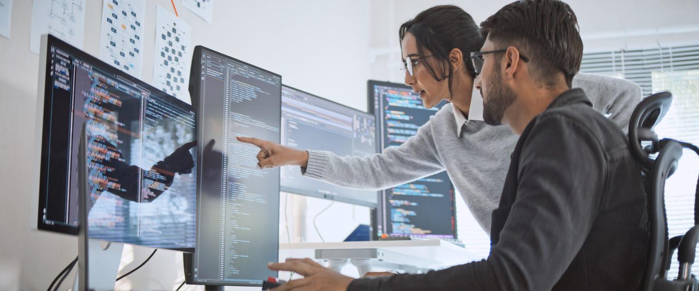 a woman points out data on a computer screen