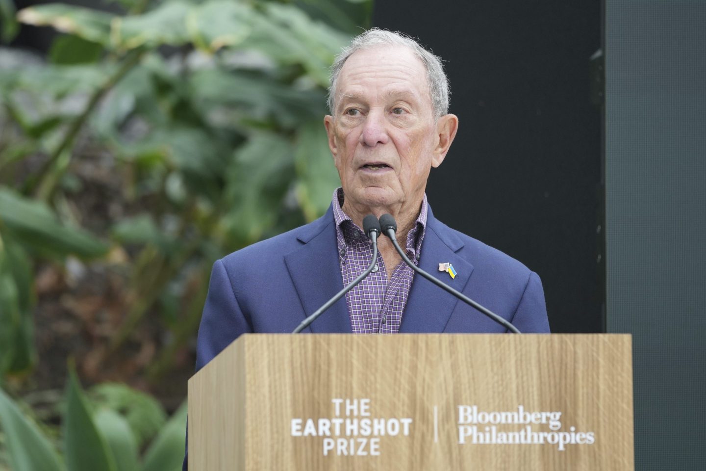Philanthropist Michael Bloomberg speaking at a podium at a climate event