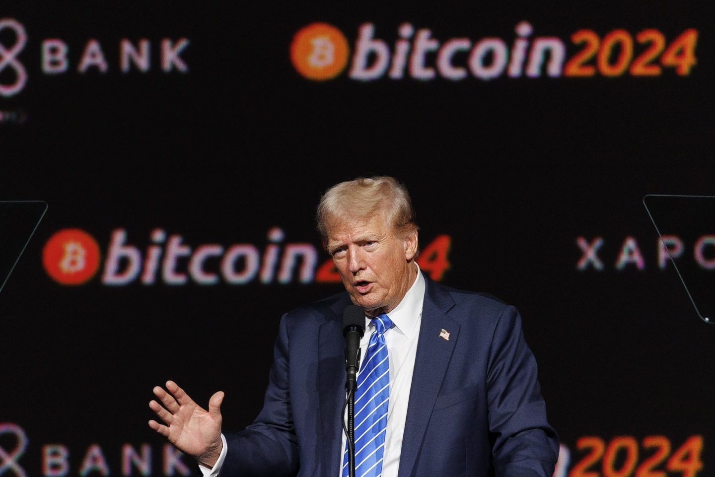Donald Trump speaks in front of a "bitcoin 2024" background